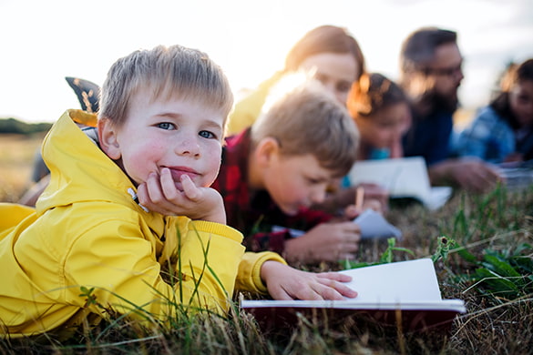 children write in notebooks on a field trip